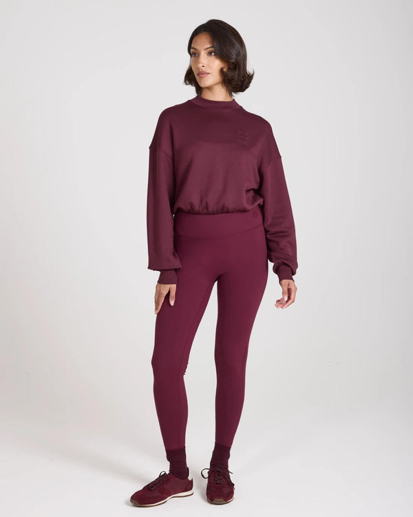 Model wearing Emello purple leggings with belt loops, showcasing a sculpting fit and high-waisted design.