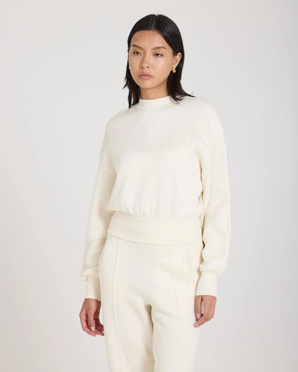 Model wearing cream sweatshirt with debossed logo, relaxed fit in luxurious lyocell.