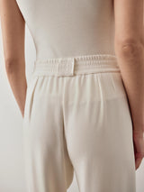 Back view of cream balloon popper trousers showcasing refined waistband detail.