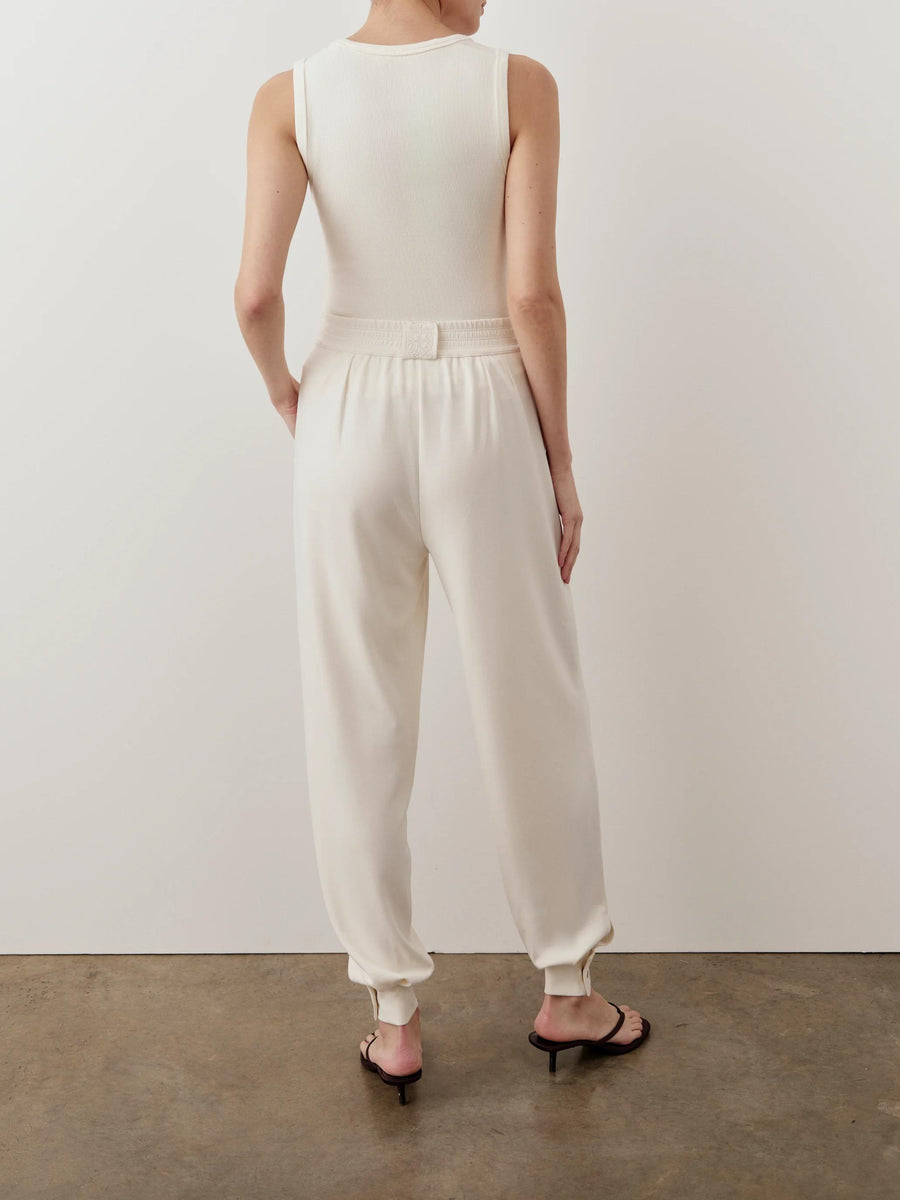 Back view of Emello's cream balloon popper trousers showcasing relaxed fit and tapered hem with adjustable poppers.