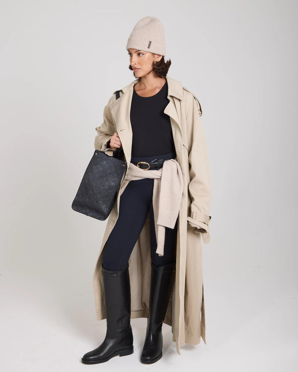 Model wearing Emello beige beanie with a trench coat and black boots