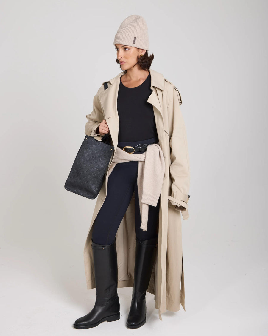 Model wearing Emello beige beanie with a trench coat and black boots