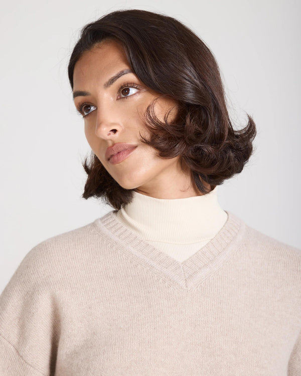 Model wearing the Kasima Cashmere Blend V Neck Sweater in beige, showcasing the relaxed fit and deep V neckline.
