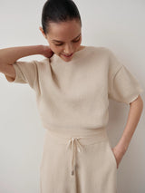 Model wearing cream Bouclé Boat Neck Top with relaxed fit and tactile finish.