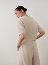 Back view of a model wearing Emello Bouclé Boat Neck Top in Cream