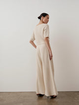 Model wearing Emello Bouclé Wide Leg Trousers in cream, showcasing a fluid drape and softly textured elegance.