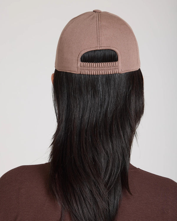 Back view of Emello Cap in taupe brushed cotton with an elasticated back band, subtly paired with flowing dark hair.