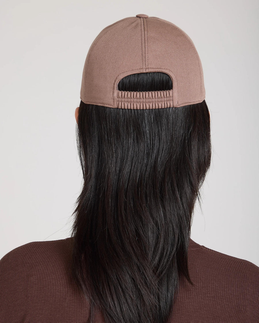 Back view of Emello Cap in taupe brushed cotton with an elasticated back band, subtly paired with flowing dark hair.