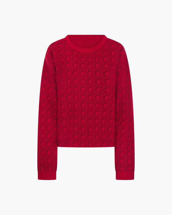 Reversible red jacquard cashmere sweater from Emello, showcasing a luxurious tactile pattern.