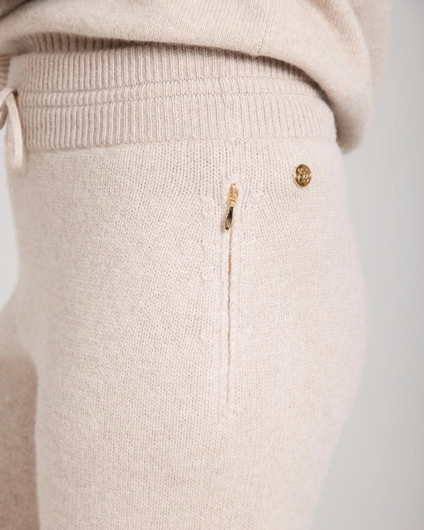 Kasima Cashmere Blend Knit Trousers in beige with ribbed waist and gold accents.