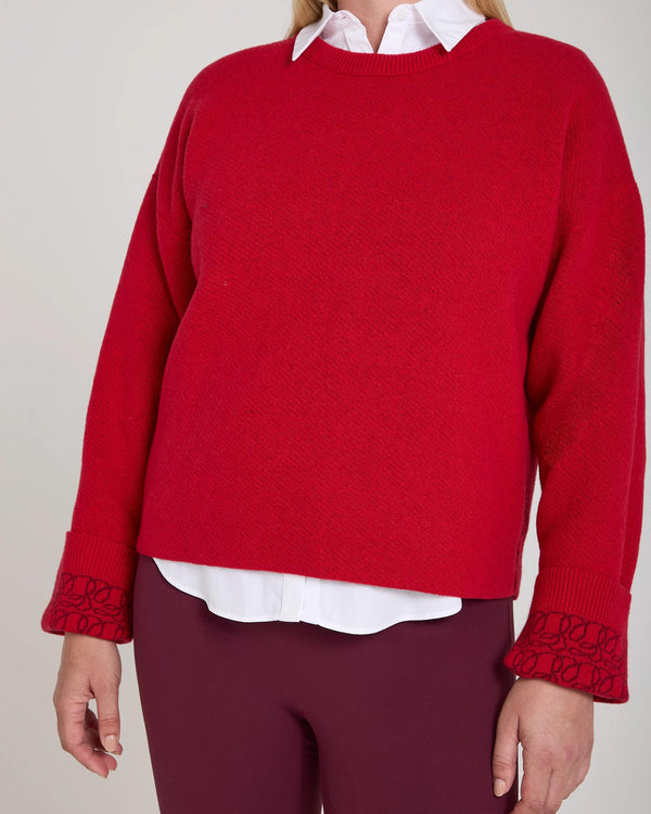 Reversible red jacquard cashmere sweater with white shirt detail, worn by a model
