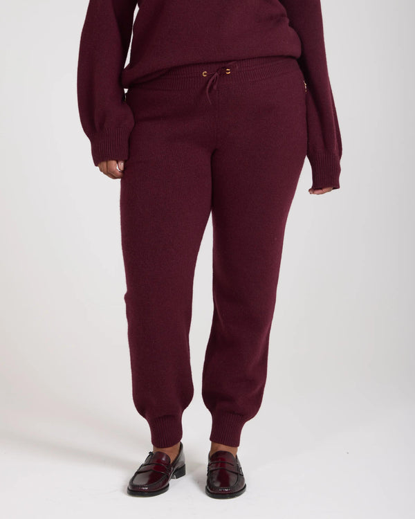 Burgundy cashmere blend knit joggers with ribbed cuffs, shown full-length against a neutral background.