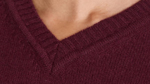 Close-up of deep wine cashmere V-neckline with soft ribbed finish