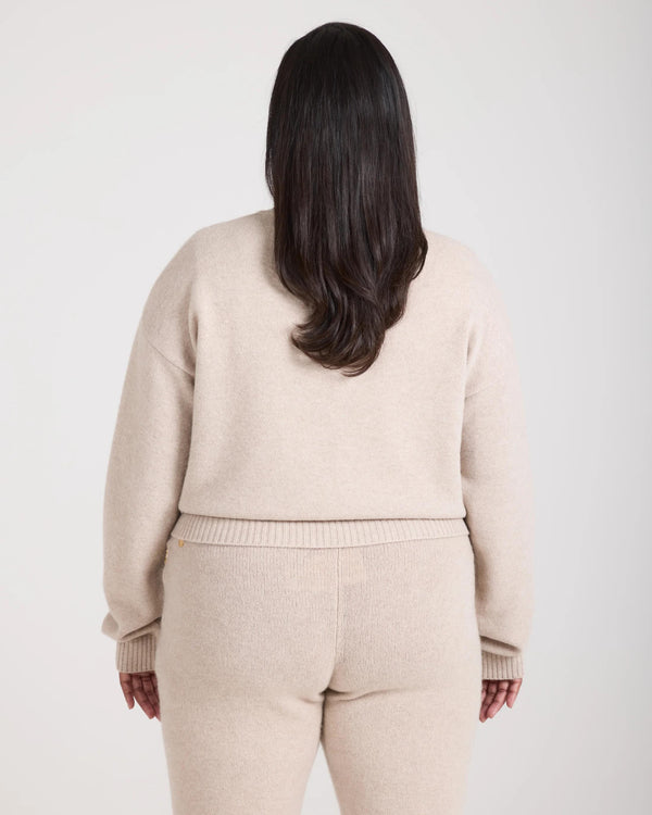 Back view of the Kasima Cashmere Blend V Neck Sweater in beige, showcasing ribbed detailing and relaxed fit.