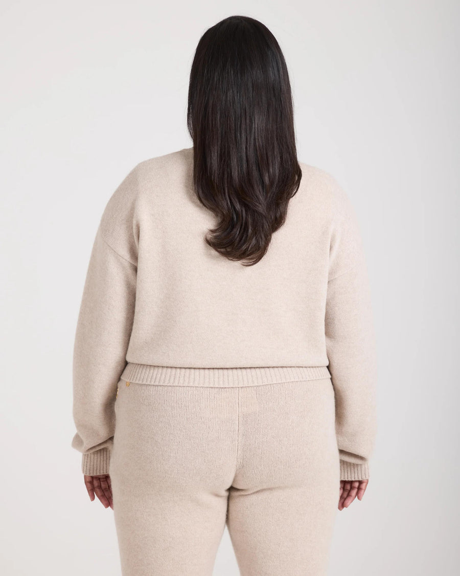 Back view of the Kasima Cashmere Blend V Neck Sweater in beige, showcasing ribbed detailing and relaxed fit.