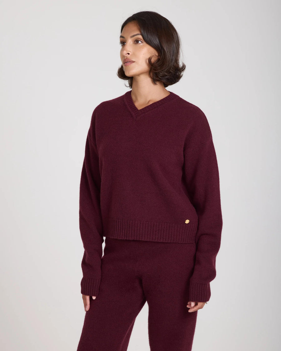 Emello Kasima Cashmere Blend V Neck Sweater in rich fig, worn by model, showcasing relaxed fit with deep ribbed details.