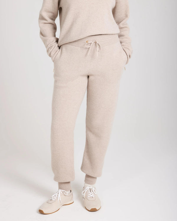 Elegant beige cashmere blend knit trousers with ribbed cuffs and drawcord, showcasing refined comfort.