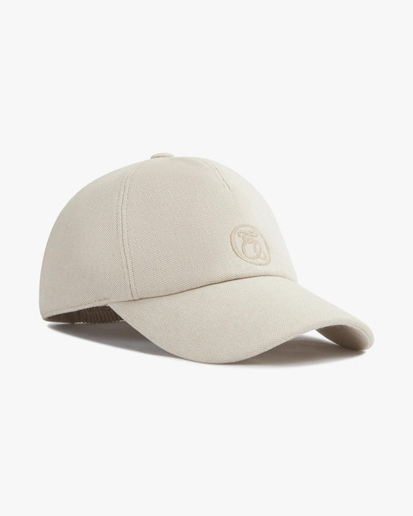 Luxury beige cotton canvas cap with a subtly shaped peak and refined embroidery, Emello AW2025 collection.