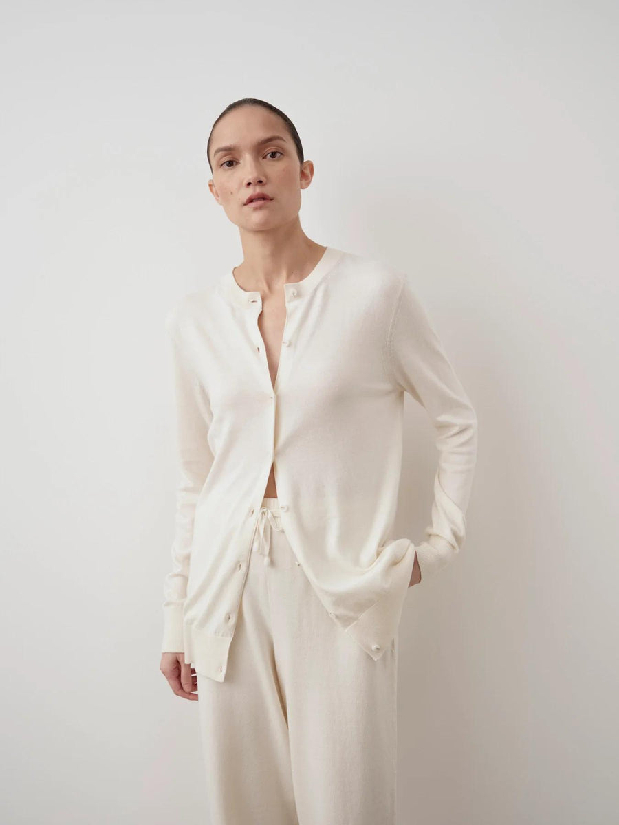 Model wearing Emello's cream cotton-cashmere cardigan, elegantly draped.