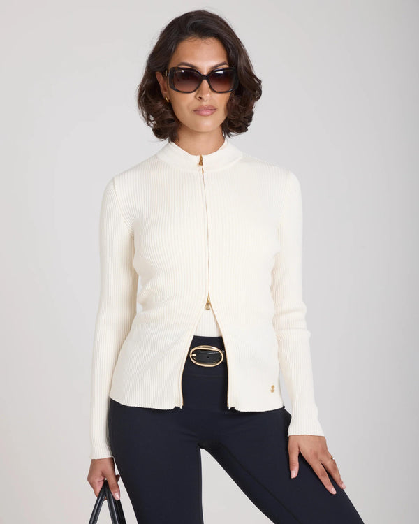 Sorella Ribbed Zip Through Cardigan in Cream, featuring a slim fit and soft ribbed texture, worn by a model.