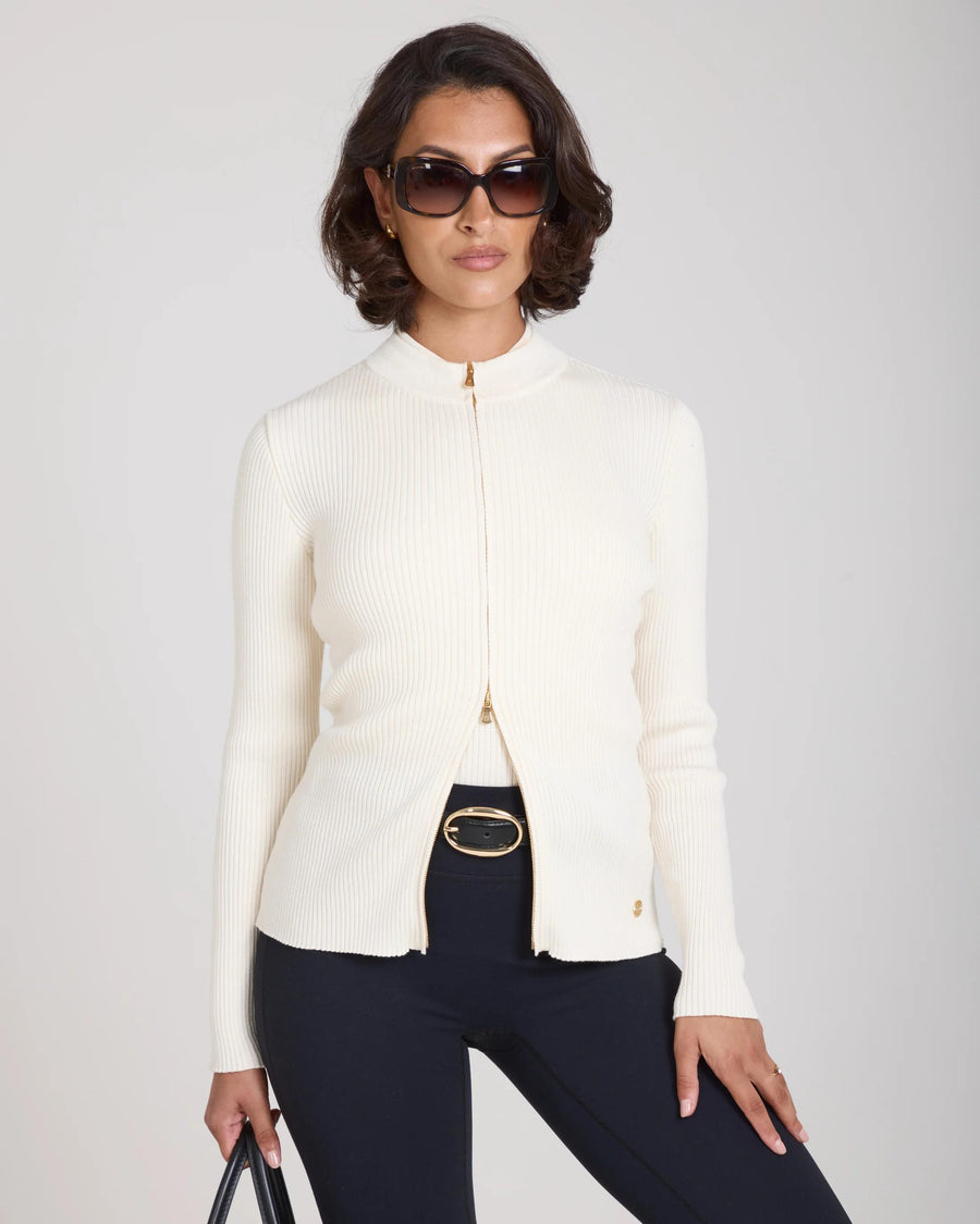 Sorella Ribbed Zip Through Cardigan in Cream, featuring a slim fit and soft ribbed texture, worn by a model.