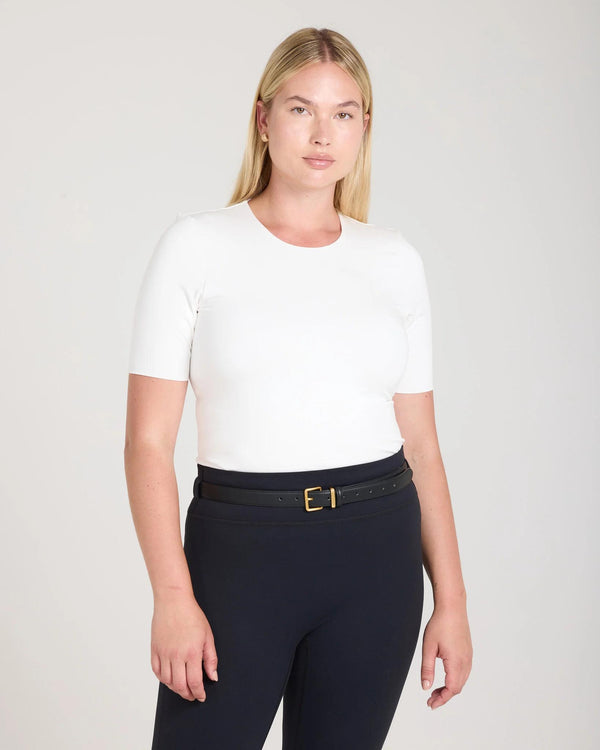 Model wearing the Emello Forma Silky Lyocell Jersey Double-Layer Top in Cream, showcasing a slim fit with short sleeves and a crew neckline.