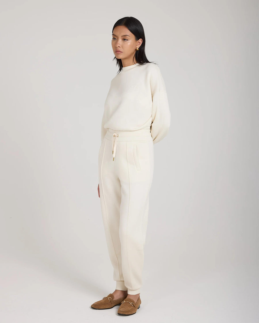 Refined cream cuffed trousers in brushed lyocell fleece, worn by a model in a poised stance.