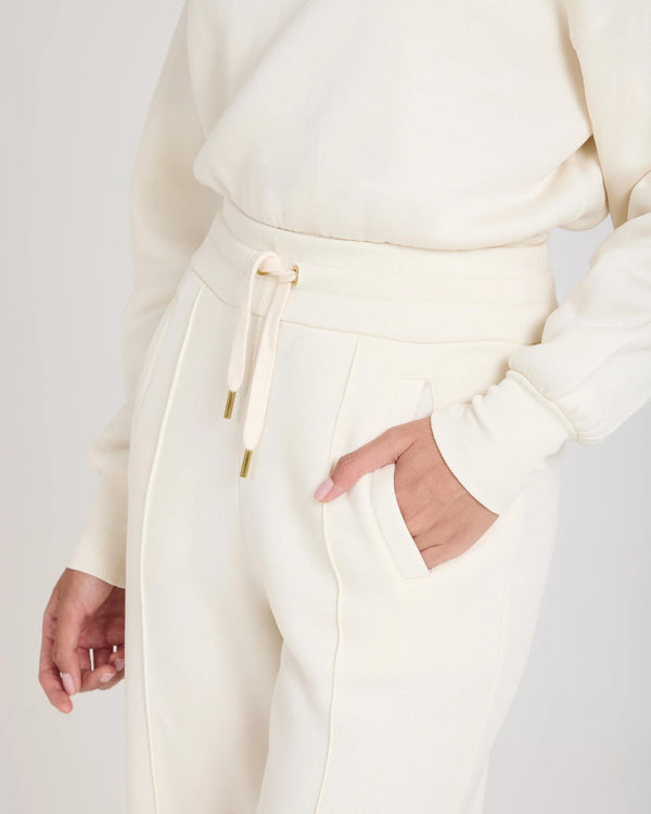 Cream cuffed trouser in brushed lyocell fleece with gold hardware and pockets by Emello.