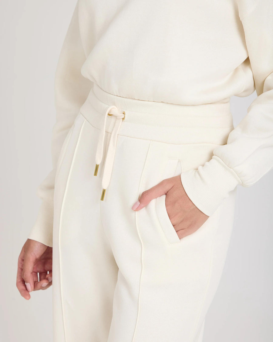 Cream cuffed trouser in brushed lyocell fleece with gold hardware and pockets by Emello.