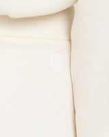 Close-up of cream cuffed trousers with Emello's logo embroidery, showcasing brushed lyocell texture.