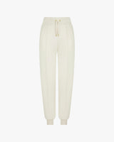 Cream cuffed trousers in brushed lyocell fleece with gold hardware and pockets, featuring refined pin-tuck detailing.