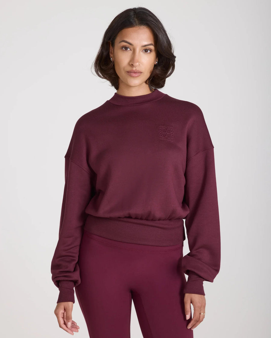 Luxury Emello sweatshirt in fig lyocell with embossed detailing, worn by model, showcasing elegant design and tactile sophistication.