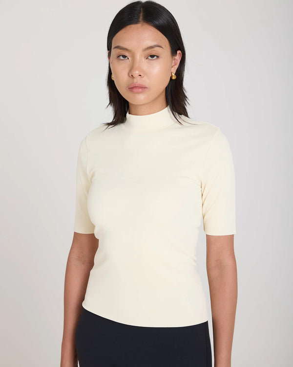 Cream double layer high neck top in viscose, worn by model, showcasing elegant and refined design.