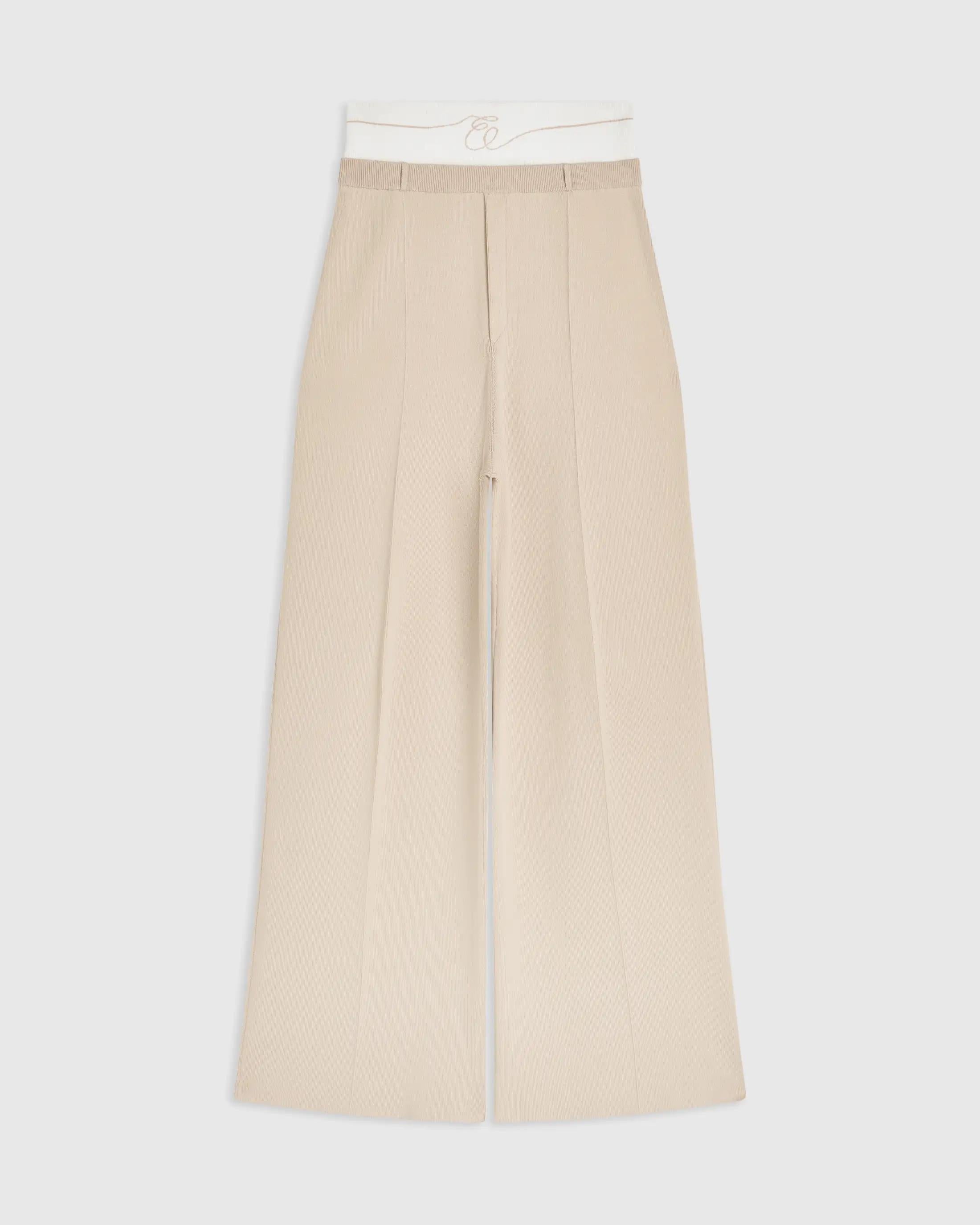 Double waistband knitted trousers in neutral tone featuring a wide-leg silhouette.