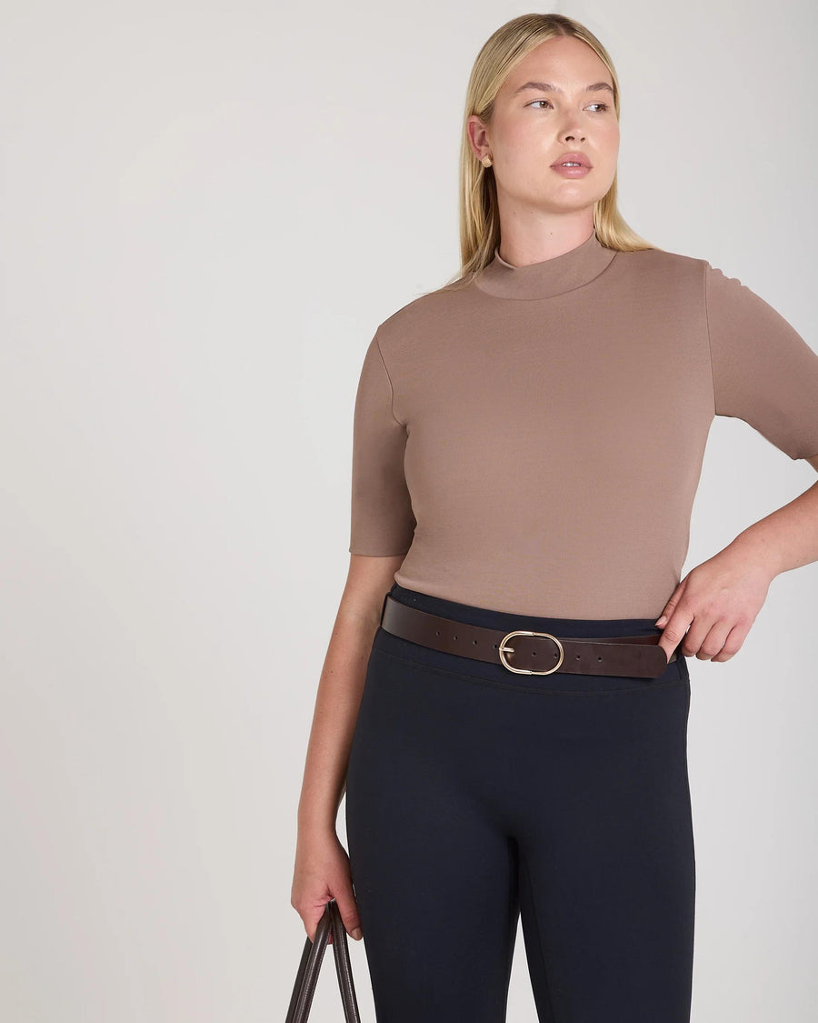 Taupe double layer high neck top in viscose, worn with dark trousers.