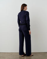 Model wearing Emello navy double waistband knitted trousers, showcasing the smooth silhouette and refined drape.
