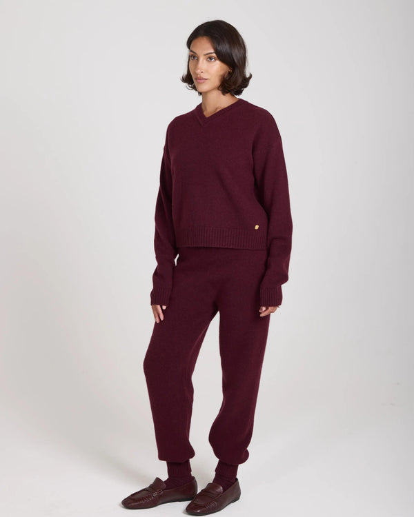 Elegant female model in a burgundy V-neck cashmere blend sweater