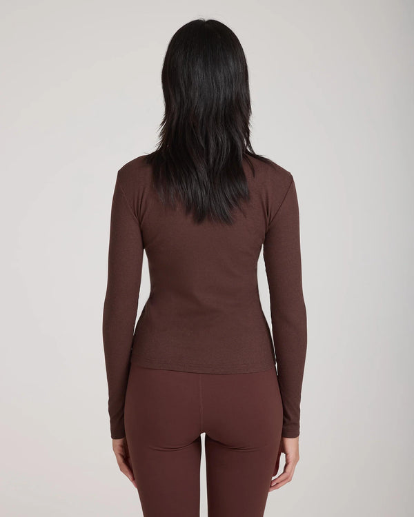 Back view of the Forma Ribbed Lyocell-Cotton Blend Turtleneck Top in Chocolate, showcasing its slim fit and ribbed texture.