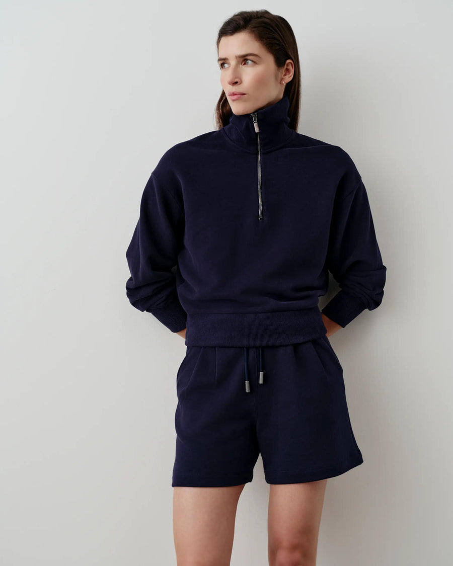 Model wearing navy half-zip funnel-neck sweatshirt, showcasing versatile elegance and refined comfort.