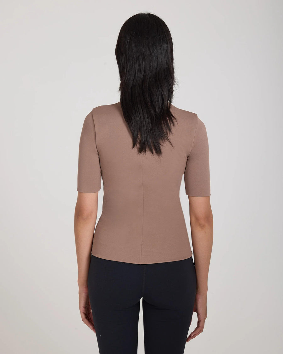 Back view of model wearing Emello's taupe double layer high neck top