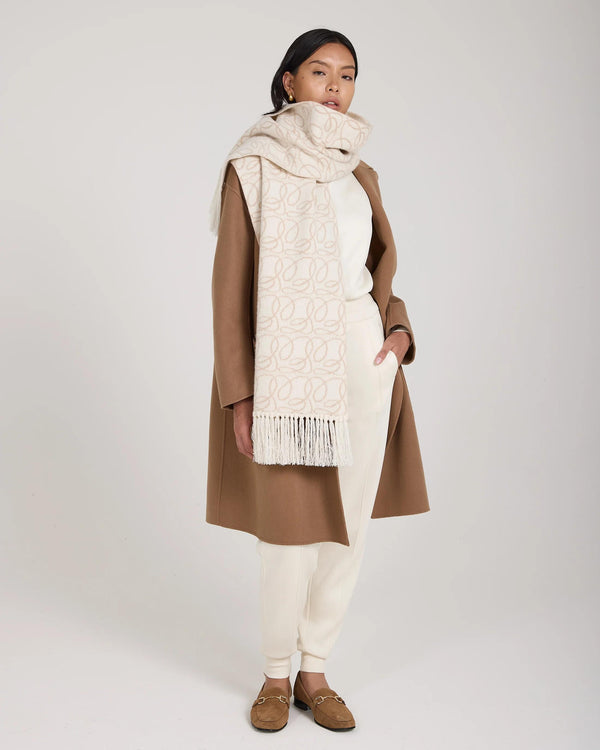 Elegant cream jacquard scarf in brushed cashmere draped gracefully with fringed tassels.