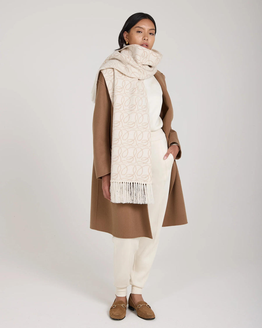 Elegant cream jacquard scarf in brushed cashmere draped gracefully with fringed tassels.
