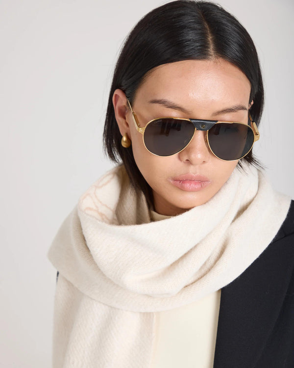 Cream jacquard scarf in brushed cashmere elegantly draped on a model wearing sunglasses, showcasing refined luxury.