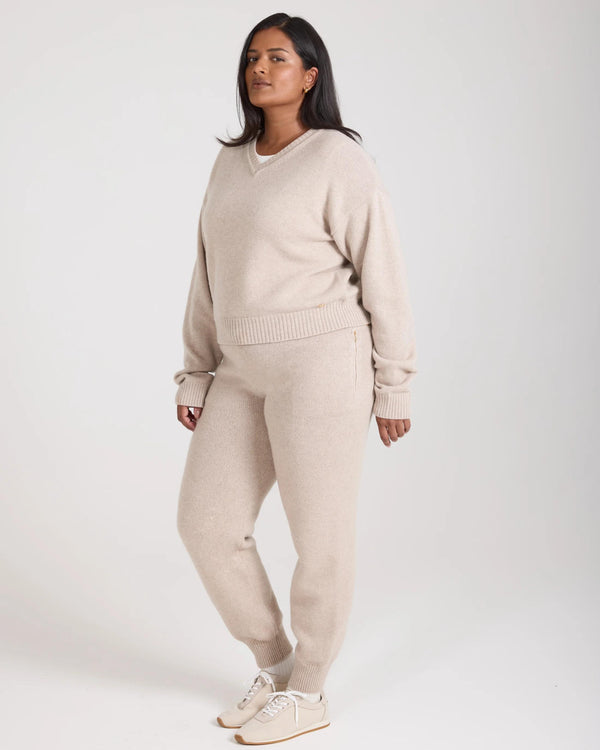 Model wearing the Kasima Cashmere Blend V Neck Sweater in beige, conveying a relaxed and elegant style.