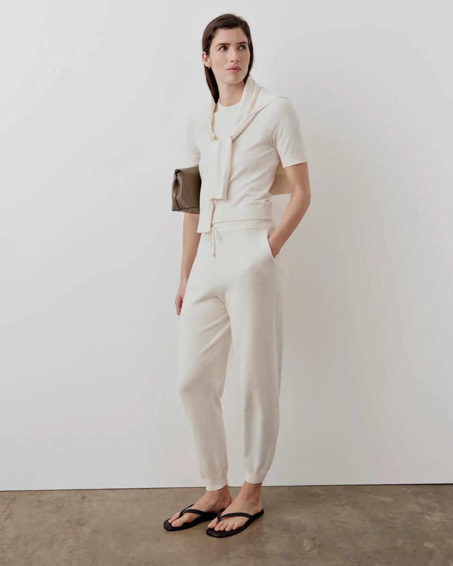 Model wearing cream cotton cashmere knit tee with matching trousers.