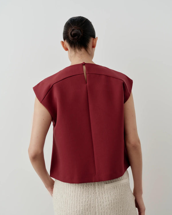 Back view of Emello Structured Layered Vest in rich fig color, showcasing architectural design and keyhole closure.