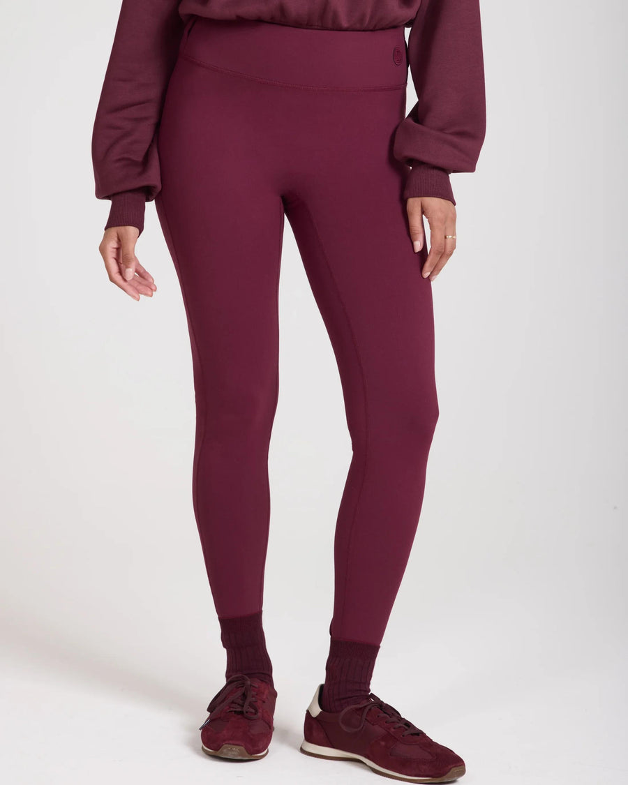Model wearing fig-colored leggings with belt loops, showcasing a high-waisted, sculpting fit.