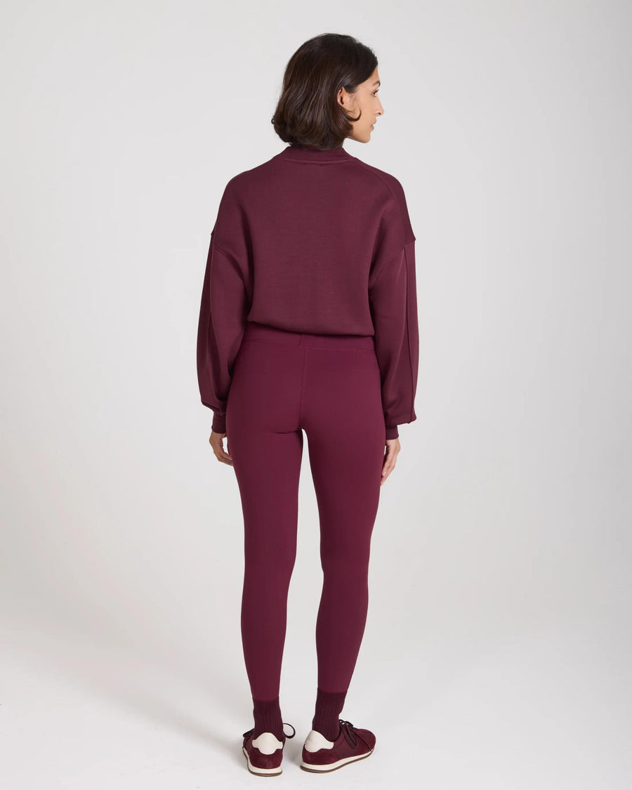 Back view of woman wearing Emello sculpted purple leggings with belt loops, embodying elegance.