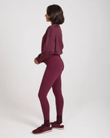 Side profile of model wearing Emello's purple leggings with belt loops, showcasing a form-fitting silhouette.