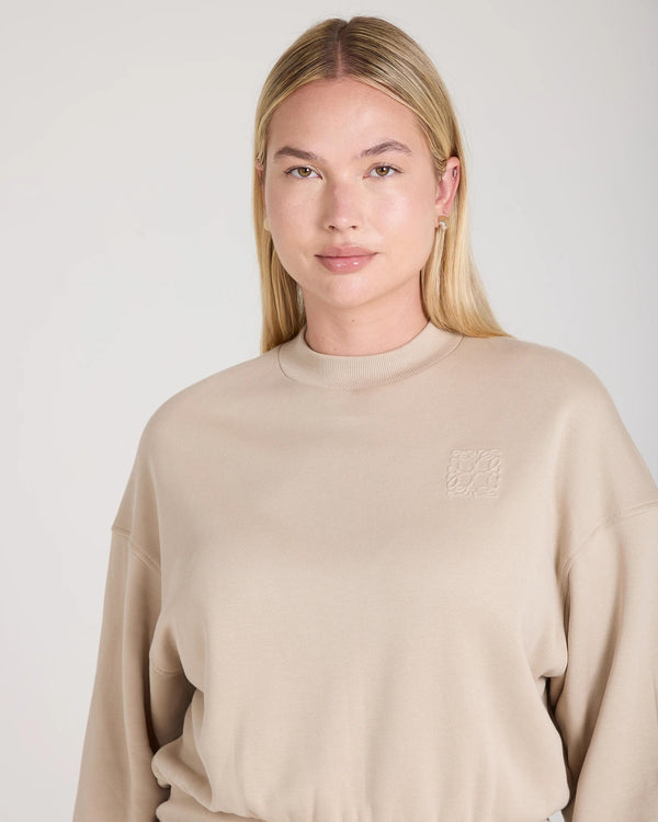 Beige Lyocell Fleece Sweatshirt by Emello with embossed logo detail, worn by model with relaxed posture.